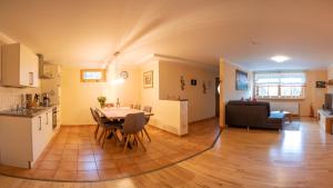 eine Küche und ein Wohnzimmer mit einem Tisch und Stühlen in der Unterkunft Ferienwohnung im Landhaus am Nationalpark in Ludwigsthal