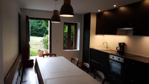 eine Küche mit einem Tisch, einem Waschbecken und einem Fenster in der Unterkunft Gîte LA BERGERIE in Neuville-Bosc