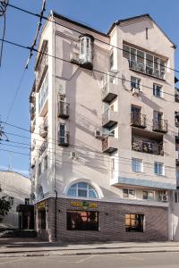 a tall white building with balconies on a street at Boutique Hotel Russkaya Okhota in Samara