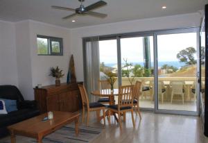 a living room with a couch and a table and chairs at Sorrento Bluewater Apartment in Perth