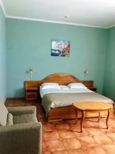 ゲレンジークにあるHotel Morskaya Zvezdaのベッドルーム1室(ベッド1台、テーブル、ソファ付)