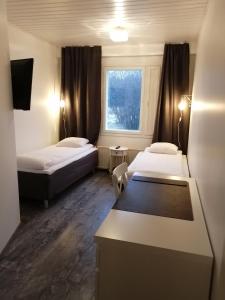 een hotelkamer met 2 bedden en een raam bij SEO Motel Alavieska in Alavieska