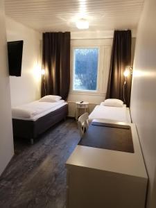 a hotel room with two beds and a window at SEO Motel Alavieska in Alavieska