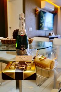 a bottle of champagne sitting on a glass table at TERRAMARIS - APARTAMENTO PÉ NA AREIA in Aquiraz