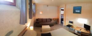 a living room with a bed and a couch at Au Coeur Des Ecrins in LʼArgentière-la-Bessée
