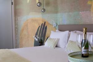 1 dormitorio con 1 cama con 2 botellas de champán en Hotel Alexandra - Beach Front -XXL Breakfast & Brunch until 12 30pm, en Misano Adriatico