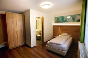 
a bedroom with a bed and a dresser at Hotel-Restaurant Ochsen in Blaubeuren
