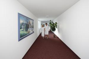 two women standing in a hallway looking at a painting at Appartement-Hotel Sibyllenbad in Neualbenreuth