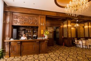a woman standing at a bar in a restaurant at Hotel Balada in Suceava