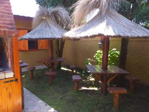 a group of picnic tables and straw umbrellas at LAS ACACIAS in Mar de Ajó