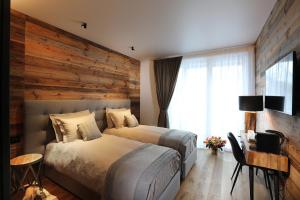 a bedroom with two beds and a wooden wall at Chalet Blanc in Breuil-Cervinia