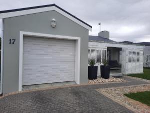 a white garage door on a white house at Heavenly Breeze in Hermanus