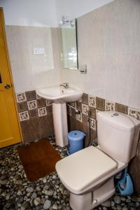 a bathroom with a toilet and a sink at Yala New Nehansa Resort in Tissamaharama