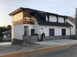 a white house with a black roof at Good times apartmán & wellness in Žilina