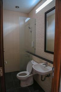 a bathroom with a toilet and a sink and a shower at Alia Home in Sanur