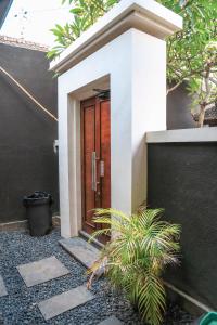 a door of a house with a plant in front at Alia Home in Sanur