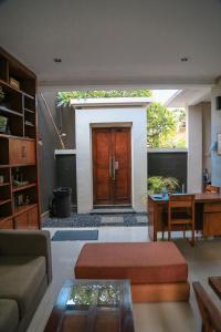 a living room with a table and a wooden door at Alia Home in Sanur