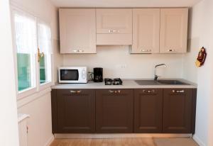 a kitchen with brown cabinets and a microwave at Ca Palazzo in Venice