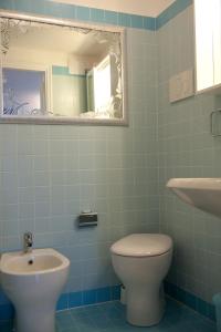 een badkamer met een toilet, een wastafel en een spiegel bij Ca Palazzo in Venetië