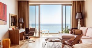 a living room with a view of the ocean at Utesov Hotel in Anapa