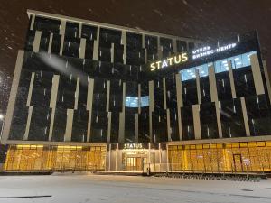 a building with a sign on it in the snow at Бутик-отель Status in Brest