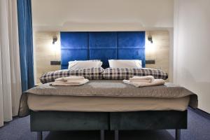 1 dormitorio con 1 cama con 2 toallas en Narciarski Dworek, en Zakopane