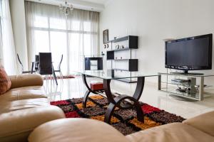 a living room with a table and a tv at HiGuests - Deluxe Apartment With Balcony and Amazing Views in Dubai