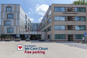 a building with a sign that says best western we care clean fire parking at Best Western Plus Hotel Amstelveen in Amstelveen