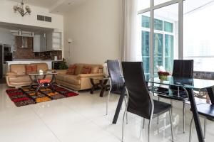 a living room with a couch and a table and chairs at HiGuests - Deluxe Apartment With Balcony and Amazing Views in Dubai