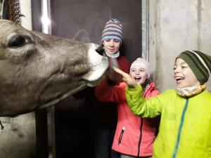 Due bambini che danno da mangiare a una giraffa allo zoo di Haus Hagspiel a Hittisau