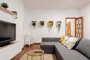 uma sala de estar com um sofá cinzento e uma televisão de ecrã plano em Casa Andrea em Las Palmas de Gran Canaria