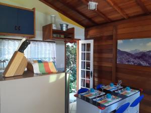 Una cocina con un refrigerador y una mesa con un cuchillo. en Chalezinho Pedra Azul, en São Pedro da Serra
