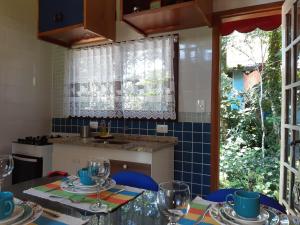 una cocina con una mesa con gafas. en Chalezinho Pedra Azul, en São Pedro da Serra