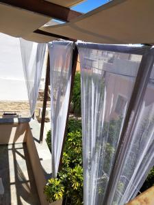 una ventana con cortinas blancas en el patio en maria's rooms syros en Ermoupoli