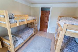 a room with three bunk beds and a door at Hostel Day 'N' Night in Niš