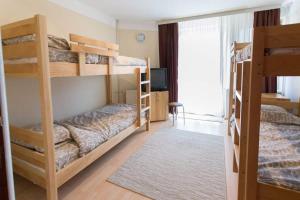a room with two bunk beds and a television at Hostel Day 'N' Night in Niš