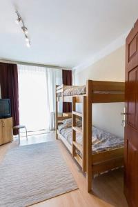 a room with two bunk beds and a tv at Hostel Day 'N' Night in Niš
