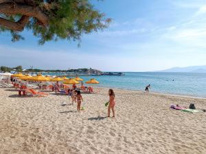 two children playing on a beach with umbrellas at Iria Beach Art Hotel in Agia Anna Naxos