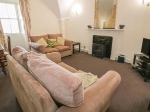 a living room with a couch and a fireplace at Brewhouse Flat - Culzean Castle in Maybole