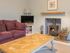 uma sala de estar com um sofá e uma lareira em East Cottage - Tarvit em Cupar
