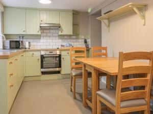 a kitchen with a wooden table and chairs at East Cottage - Tarvit in Cupar