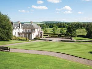un grand domaine avec un banc dans l'herbe dans l'établissement East Cottage - Tarvit, à Cupar