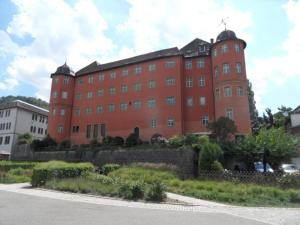 ein großes rotes Backsteingebäude mit einem Turm in der Unterkunft Hotel Gasthof zum Engel in Künzelsau