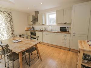 a kitchen with a wooden table and a dining room at Ardlochan Lodge - Culzean Castle in Maybole