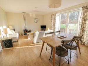 a living room with a table and chairs and a couch at Ardlochan Lodge - Culzean Castle in Maybole