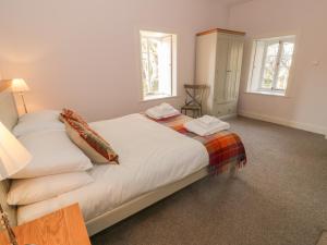 Maybole的住宿－Ardlochan Lodge - Culzean Castle，一间卧室设有一张床和两个窗户。