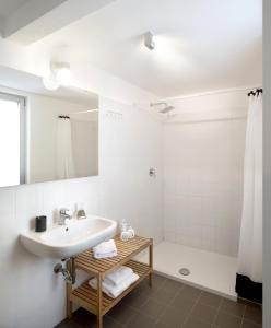 een witte badkamer met een wastafel en een douche bij UP to home - Città Studi in Milaan