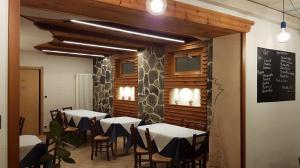 ein Restaurant mit Tischen und Stühlen in einem Raum in der Unterkunft Maison Manu in Perosa Argentina