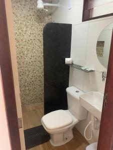 a bathroom with a white toilet and a sink at Pousada Grandmar, Maragogi in Maragogi