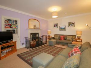 a living room with a couch and a tv at Inverewe - Garden Lodge in Achnasheen